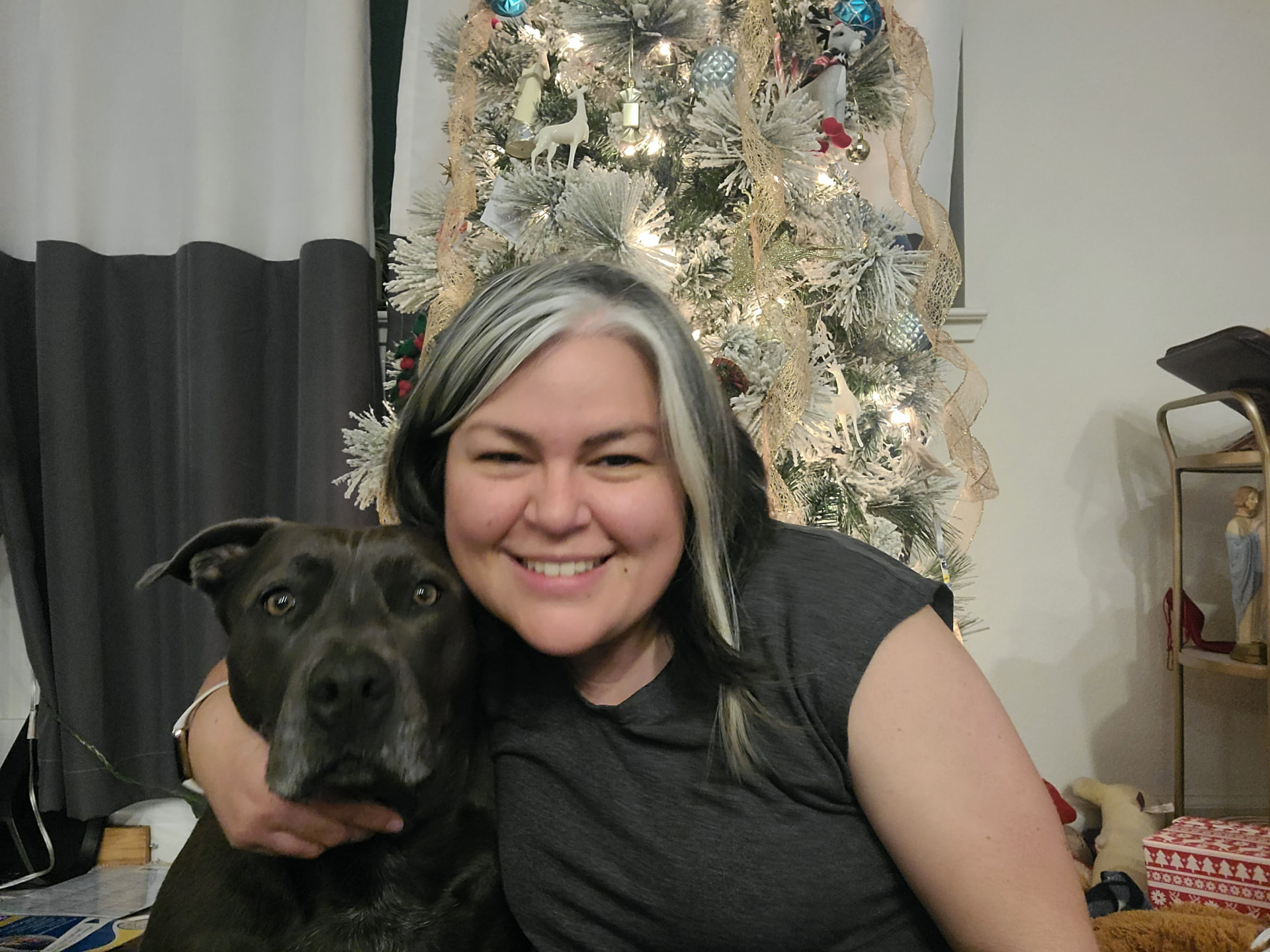 Betty Davis, a UX designer with her dog in front of a decorated tree